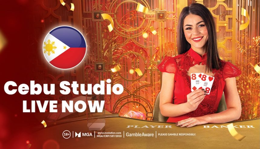 Promotional image for Evolution Gaminmg’s Cebu Studio: a round Philippine flag badge at left with bold text “Cebu Studio LIVE NOW,” set against an ornate gold studio background with confetti. A dealer in red holds playing cards at a table labeled “Player / Banker.” Footer shows regulator and responsible-gambling icons. Visual cues highlight a localized Filipino studio, live dealer gameplay, studio-grade production, and mobile-friendly streaming.